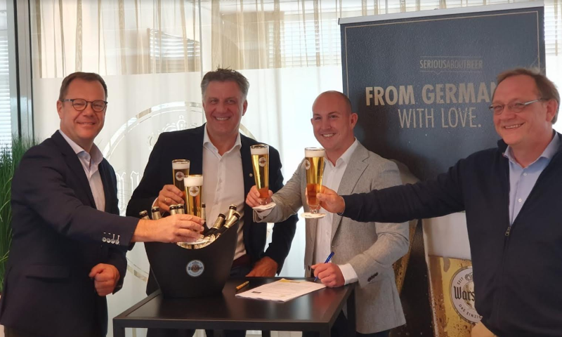 Vier mannen proosten met een glas Warsteiner pils op de samenwerking tussen Makro en Warsteiner